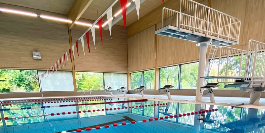 Schwimmhalle mit Sportbecken und Sprungturm